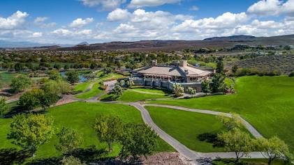 Aerial view of an Anthem Country Club clubhouse, manicured fairways in front and desert mountain backdrop