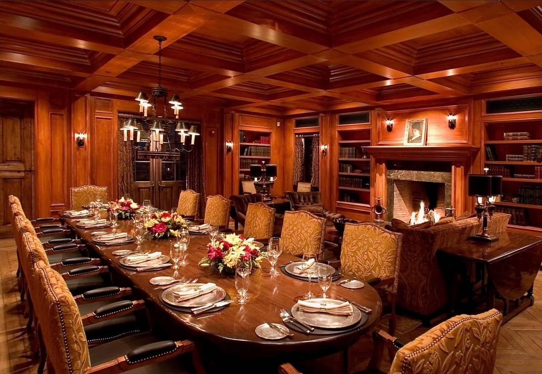 The Silverleaf Club clubhouse private dining room — a long set table in a wood-paneled room with bookcases and a lit fireplace